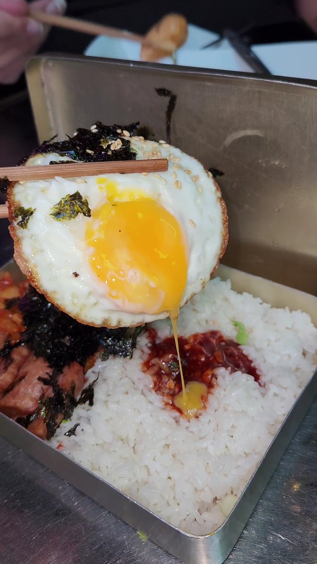 Packed rice box with egg, seaweed, and kimchi